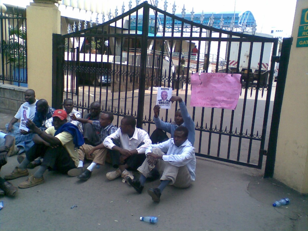 Sam Ongeri and his minions at the ministry of Education stole Kshs 4.2 Billion that was meant to fund for free primary school education in Kenya. In this picture a group of people sit outside his offices demanding that he resign, or be fired.